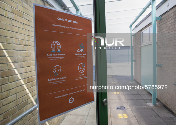   A COVID-19 poster on the door with footprints leading into the distance. Ortu Gable Hall School in Corringham, Essex return after a long b...