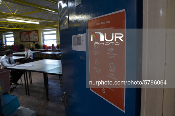   A COVID-19 poster on the door with the year 10 class inside. Ortu Gable Hall School in Corringham, Essex return after a long break due to...