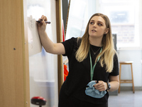  A teacher at the front of a class of Year 10 pupils . Ortu Gable Hall School in Corringham, Essex return after a long break due to the COVI...