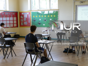   A teacher at the front of a class of Year 12 pupils. Ortu Gable Hall School in Corringham, Essex return after a long break due to the COVI...