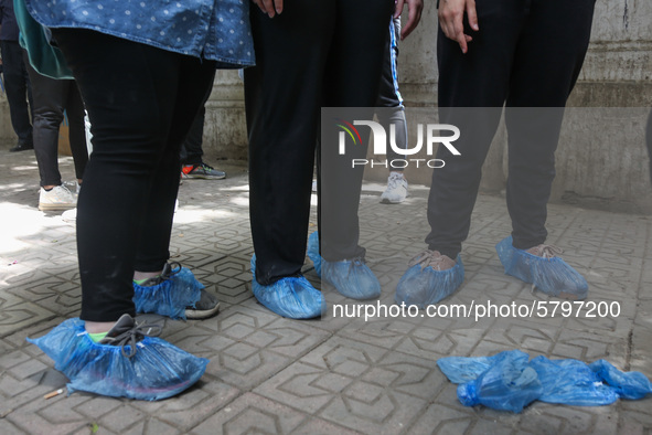 the students wear foot gloves during the first day of the high school exams in Giza Governorate, Egypt, on June 21, 2020.  