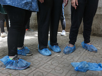 the students wear foot gloves during the first day of the high school exams in Giza Governorate, Egypt, on June 21, 2020.  (