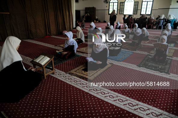 Girls keeping a safe distance from each other,attend a Koran memorization class as Palestinians ease the coronavirus disease (COVID-19) rest...