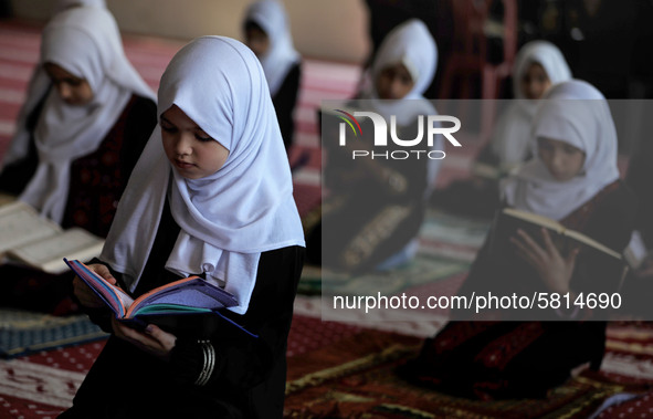 Girls keeping a safe distance from each other,attend a Koran memorization class as Palestinians ease the coronavirus disease (COVID-19) rest...