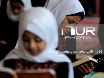 Girls keeping a safe distance from each other,attend a Koran memorization class as Palestinians ease the coronavirus disease (COVID-19) rest...