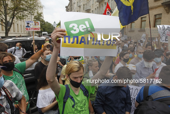 A participant holds a poster reading like 'Ze! plagiarist', during a rally of Ukrainian students against the appointment of acting Minister...