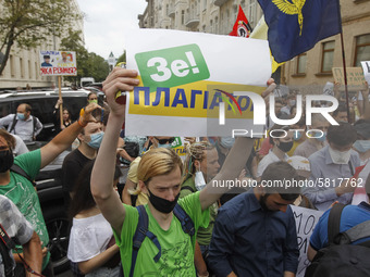 A participant holds a poster reading like 'Ze! plagiarist', during a rally of Ukrainian students against the appointment of acting Minister...