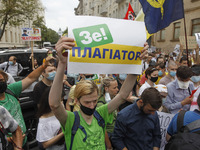 A participant holds a poster reading like 'Ze! plagiarist', during a rally of Ukrainian students against the appointment of acting Minister...