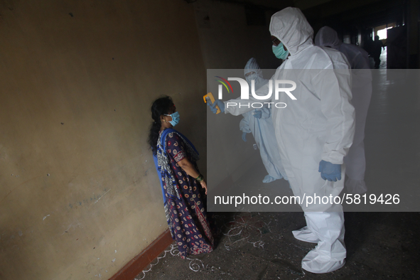 A healthcare worker checks the temperature of a woman during a medical check-up in Mumbai, India on July 01, 2020. India is the fourth worst...