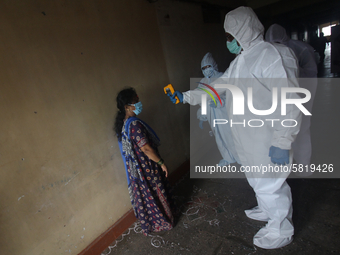 A healthcare worker checks the temperature of a woman during a medical check-up in Mumbai, India on July 01, 2020. India is the fourth worst...