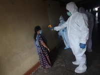 A healthcare worker checks the temperature of a woman during a medical check-up in Mumbai, India on July 01, 2020. India is the fourth worst...