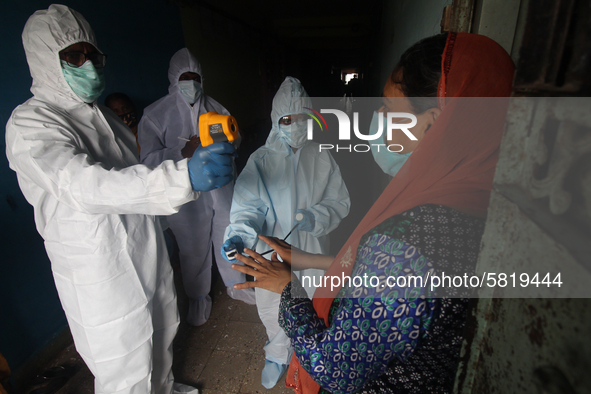 A healthcare worker checks the temperature of a woman during a medical check-up in Mumbai, India on July 01, 2020. India is the fourth worst...