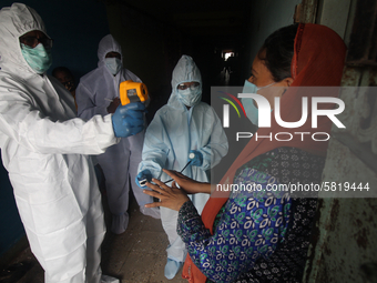 A healthcare worker checks the temperature of a woman during a medical check-up in Mumbai, India on July 01, 2020. India is the fourth worst...