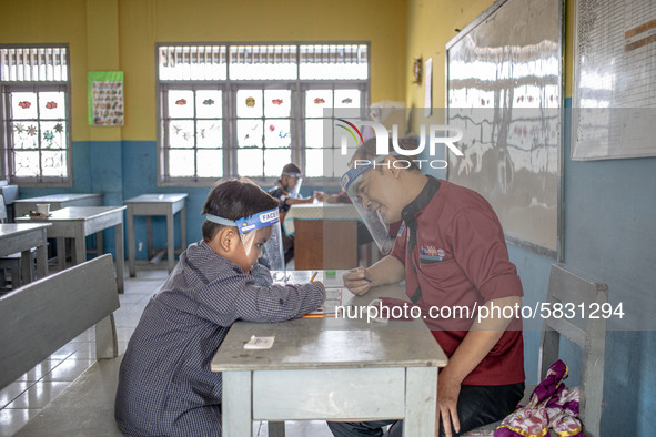 A teacher guide a little boy during his test for entering the school in Depok, West Java, Indonesia, on July 6, 2020.  The Education and Cul...