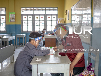 A teacher guide a little boy during his test for entering the school in Depok, West Java, Indonesia, on July 6, 2020.  The Education and Cul...