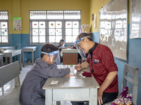 A teacher guide a little boy during his test for entering the school in Depok, West Java, Indonesia, on July 6, 2020.  The Education and Cul...