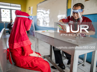 A teacher checking document of a little girl participant for the selection test for entering the school at Depok, West Java, Indonesia, on J...