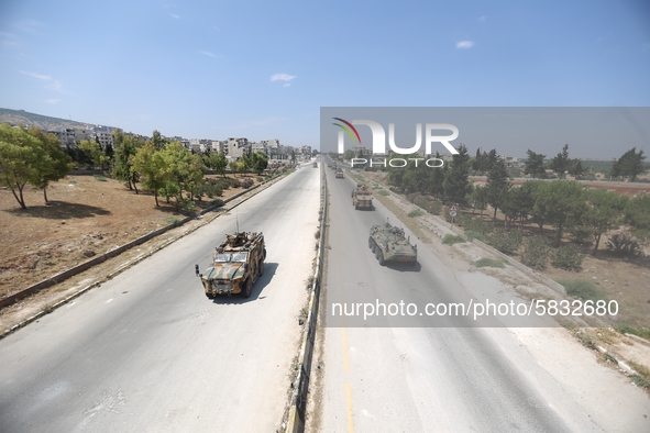 Russian and Turkish military armored vehicles and armored personnel carriers travel together on a joint patrol along the international road...