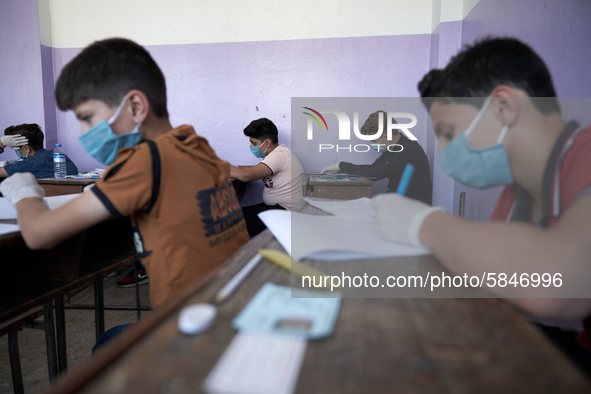 Syrian students in Idlib province take the middle school exam while maintaining safety procedures against the Coronavirus on July 12, 2020 