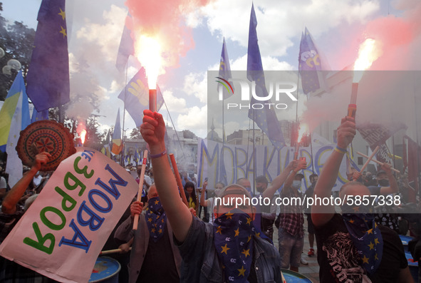 Ukrainians burn flares during a rally in support Ukrainian language and against a bill which offers to extend the use of the Russian languag...