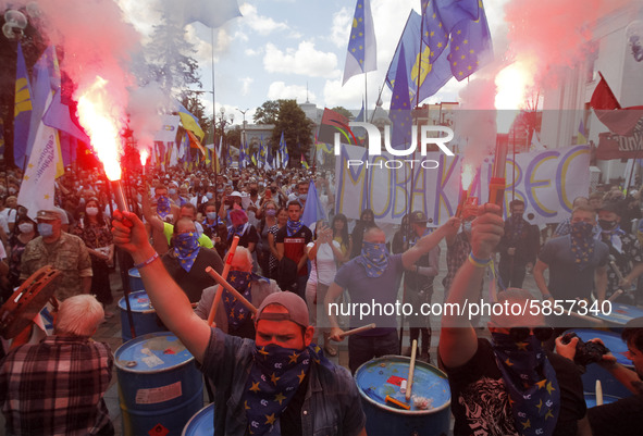 Ukrainians burn flares during a rally in support Ukrainian language and against a bill which offers to extend the use of the Russian languag...