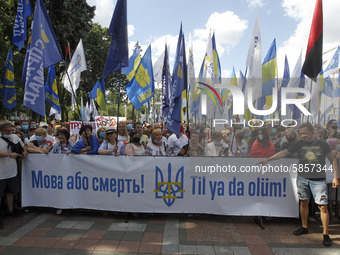 Ukrainians hold a banner reading like 'The language or death!' during a rally in support Ukrainian language and against a bill which offers...