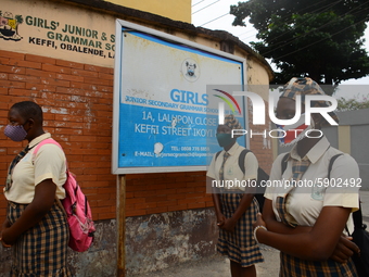 High school students wear face masks as they wait outside the entrance of Girls Junior Grammar School, S.W, Ikoyi, Lagos on August 3, 2020 o...