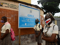 High school students wear face masks as they wait outside the entrance of Girls Junior Grammar School, S.W, Ikoyi, Lagos on August 3, 2020 o...