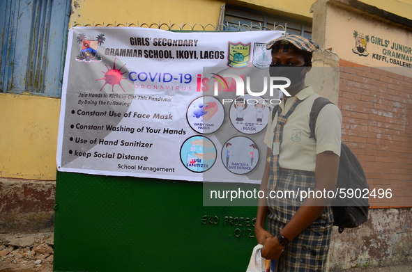 A High school student wear face mask as she wait outside the entrance of Girls Junior Grammar School, S.W, Ikoyi, Lagos on August 3, 2020 on...