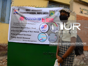 A High school student wear face mask as she wait outside the entrance of Girls Junior Grammar School, S.W, Ikoyi, Lagos on August 3, 2020 on...