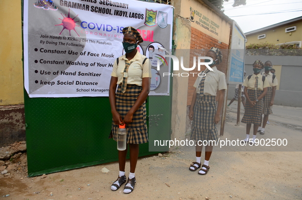 High school students wear face masks as they wait outside the entrance of Girls Junior Grammar School, S.W, Ikoyi, Lagos on August 3, 2020 o...