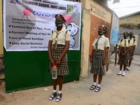 High school students wear face masks as they wait outside the entrance of Girls Junior Grammar School, S.W, Ikoyi, Lagos on August 3, 2020 o...