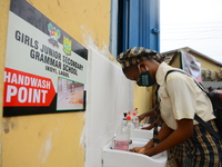 High school student wear face mask as they wash their hands in a wash hand basin at the entrance of Girls Junior Grammar School, S.W, Ikoyi,...