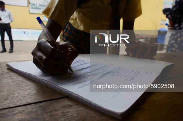 A High school student record her temperature check in a school register at the entrance of Girls Junior Grammar School, S.W, Ikoyi, Lagos on...