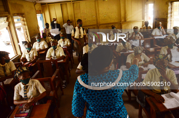 A teacher gives a lesson to students at Girls Junior Grammar School, S.W, Ikoyi, Lagos on August 3, 2020 on the first day after resumption o...