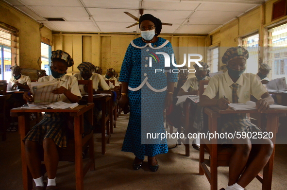 A teacher gives a lesson to students at Girls Junior Grammar School, S.W, Ikoyi, Lagos on August 3, 2020 on the first day after resumption o...