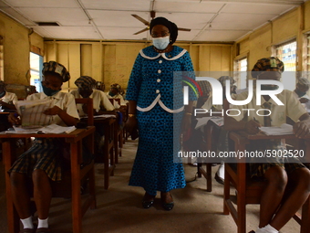 A teacher gives a lesson to students at Girls Junior Grammar School, S.W, Ikoyi, Lagos on August 3, 2020 on the first day after resumption o...