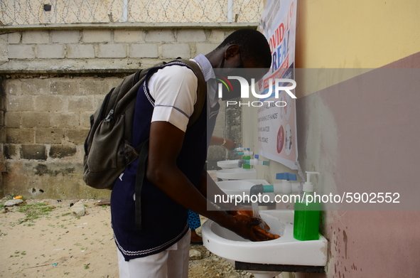 High school students wash their hands in a wash hand basin at the entrance of Ireti Junior Grammar Schol, Ikoyi, Lagos on August 3, 2020 on...