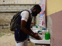 High school students wash their hands in a wash hand basin at the entrance of Ireti Junior Grammar Schol, Ikoyi, Lagos on August 3, 2020 on...