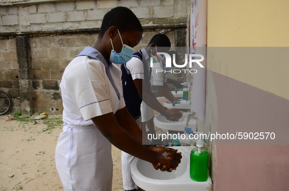 High school students wash their hands in a wash hand basin at the entrance of Ireti Junior Grammar Schol, Ikoyi, Lagos on August 3, 2020 on...