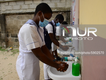 High school students wash their hands in a wash hand basin at the entrance of Ireti Junior Grammar Schol, Ikoyi, Lagos on August 3, 2020 on...