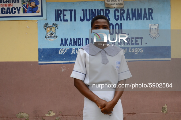 A High school student with a face mask pose for a photo at the entrance of Ireti Junior Grammar Schol, Ikoyi, Lagos on August 3, 2020 on the...