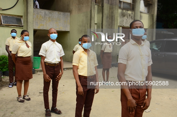 High school students with faces masks pose for a photo at the entrance of Ireti Junior Grammar Schol, Ikoyi, Lagos on August 3, 2020 on the...