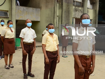 High school students with faces masks pose for a photo at the entrance of Ireti Junior Grammar Schol, Ikoyi, Lagos on August 3, 2020 on the...