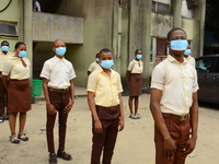 High school students with faces masks pose for a photo at the entrance of Ireti Junior Grammar Schol, Ikoyi, Lagos on August 3, 2020 on the...