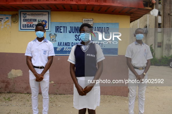 High school students with faces masks pose for a photo at the entrance of Ireti Junior Grammar Schol, Ikoyi, Lagos on August 3, 2020 on the...