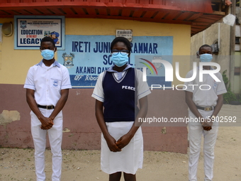 High school students with faces masks pose for a photo at the entrance of Ireti Junior Grammar Schol, Ikoyi, Lagos on August 3, 2020 on the...