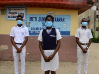 High school students with faces masks pose for a photo at the entrance of Ireti Junior Grammar Schol, Ikoyi, Lagos on August 3, 2020 on the...