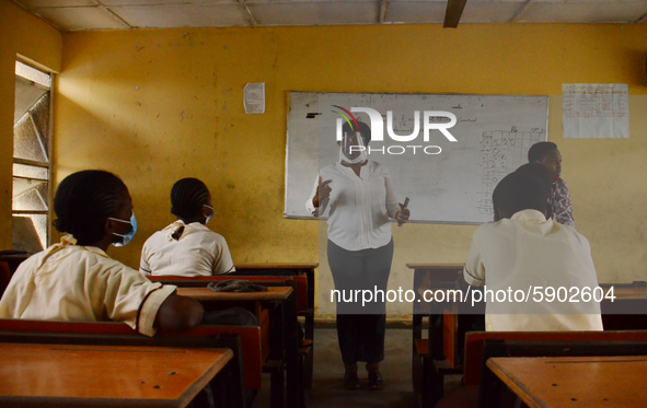 A teacher with a face mask gives a lesson to students at Ireti Junior Grammar Schol, Ikoyi, Lagos on August 3, 2020 on the first day after r...