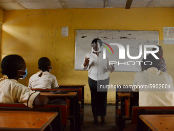 A teacher with a face mask gives a lesson to students at Ireti Junior Grammar Schol, Ikoyi, Lagos on August 3, 2020 on the first day after r...